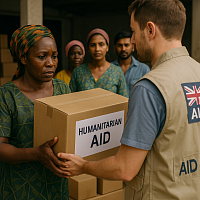 A British aid worker hands a humanitarian relief box to an African woman during a targeted aid distribution. The aid worker wears a vest with a Union Jack patch, while other recipients watch in the background. The scene reflects strategic, emergency-focused foreign aid aligned with national interests.